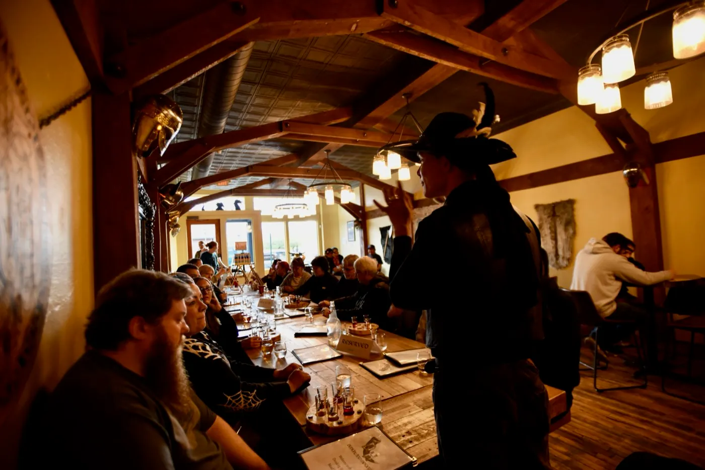Lit by mason-jar lanterns, a Freaky Foot Tours storyteller in a feathered hat works the tables of a Flagstaff bar during the adults-only pub crawl